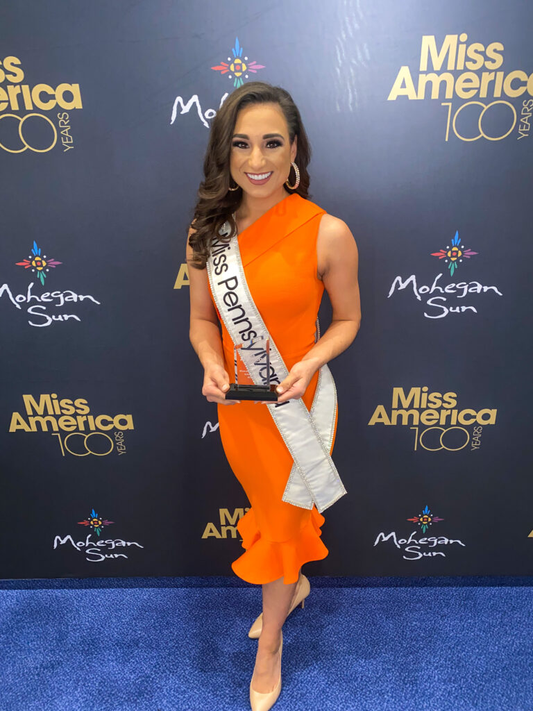 Meghan Sinisi portrait in front of Miss America step and repeat.