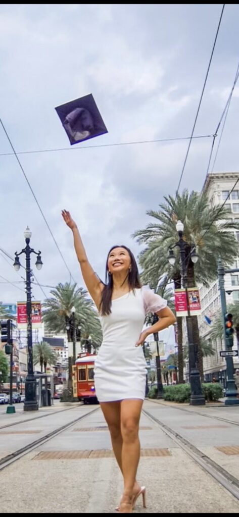 Vivian Zhong throws her graduation cap in the air.